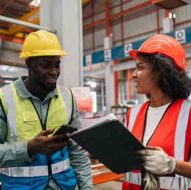 Lean management team reviewing workplace organisation and process improvement procedures in a manufacturing facility