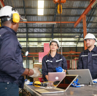 Internal quality auditor reviewing manufacturing procedures and compliance records in a production environment